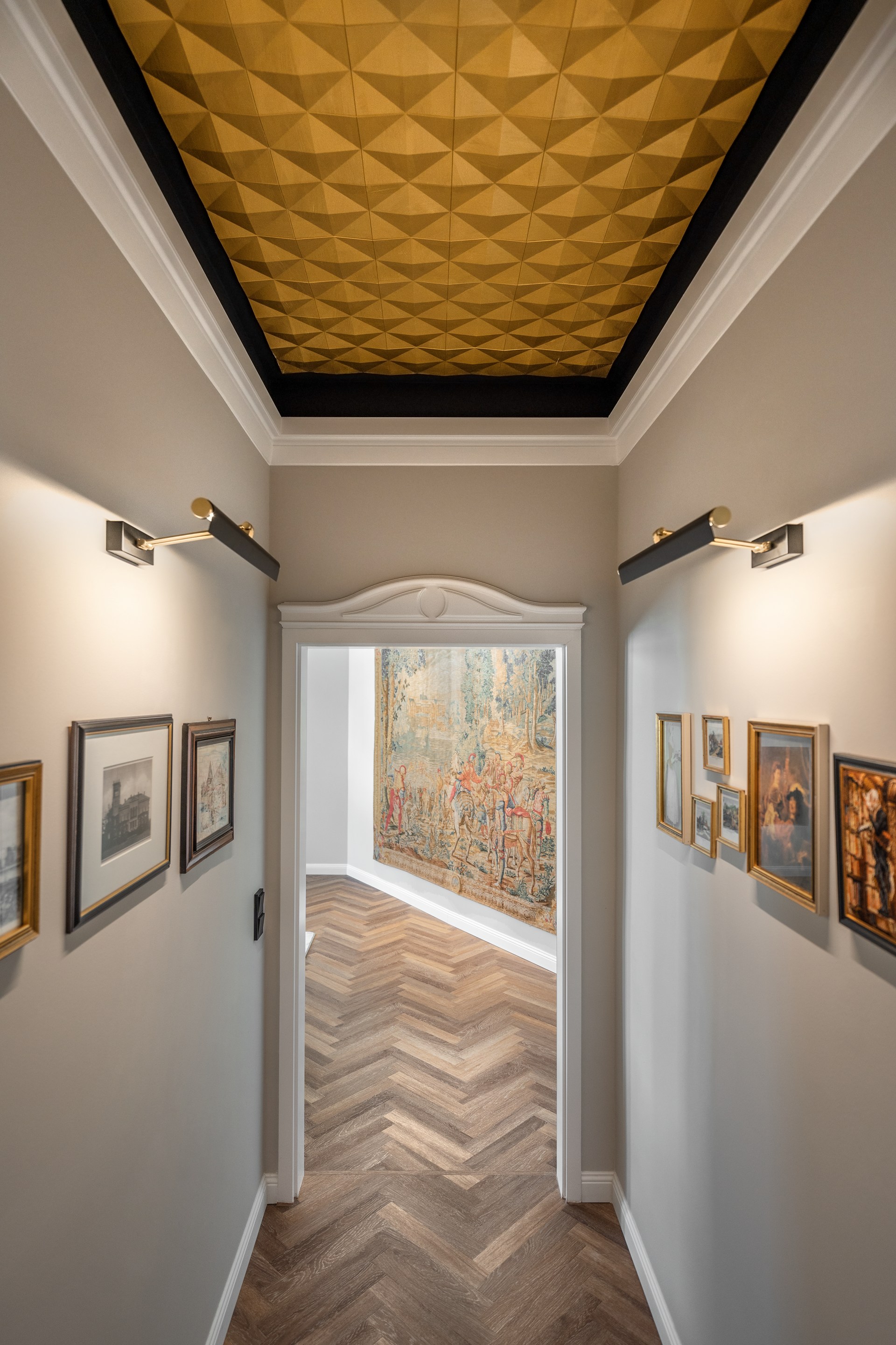 Geometrische wandpanelen zijn aan het plafond bevestigd, waardoor een sculpturaal plafondelement met een sterke architectonische diepte is ontstaan.