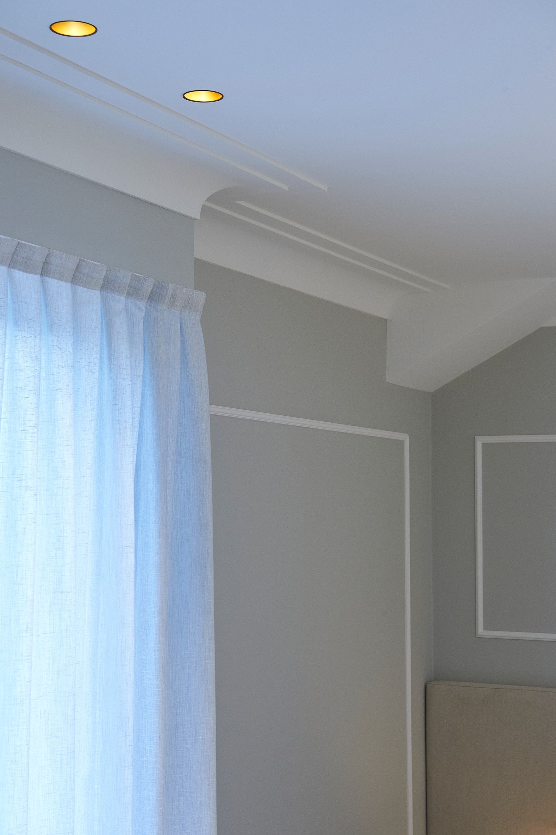 Minimalistische plafondlijsten die de overgang tussen muur en plafond in een modern interieur markeren.